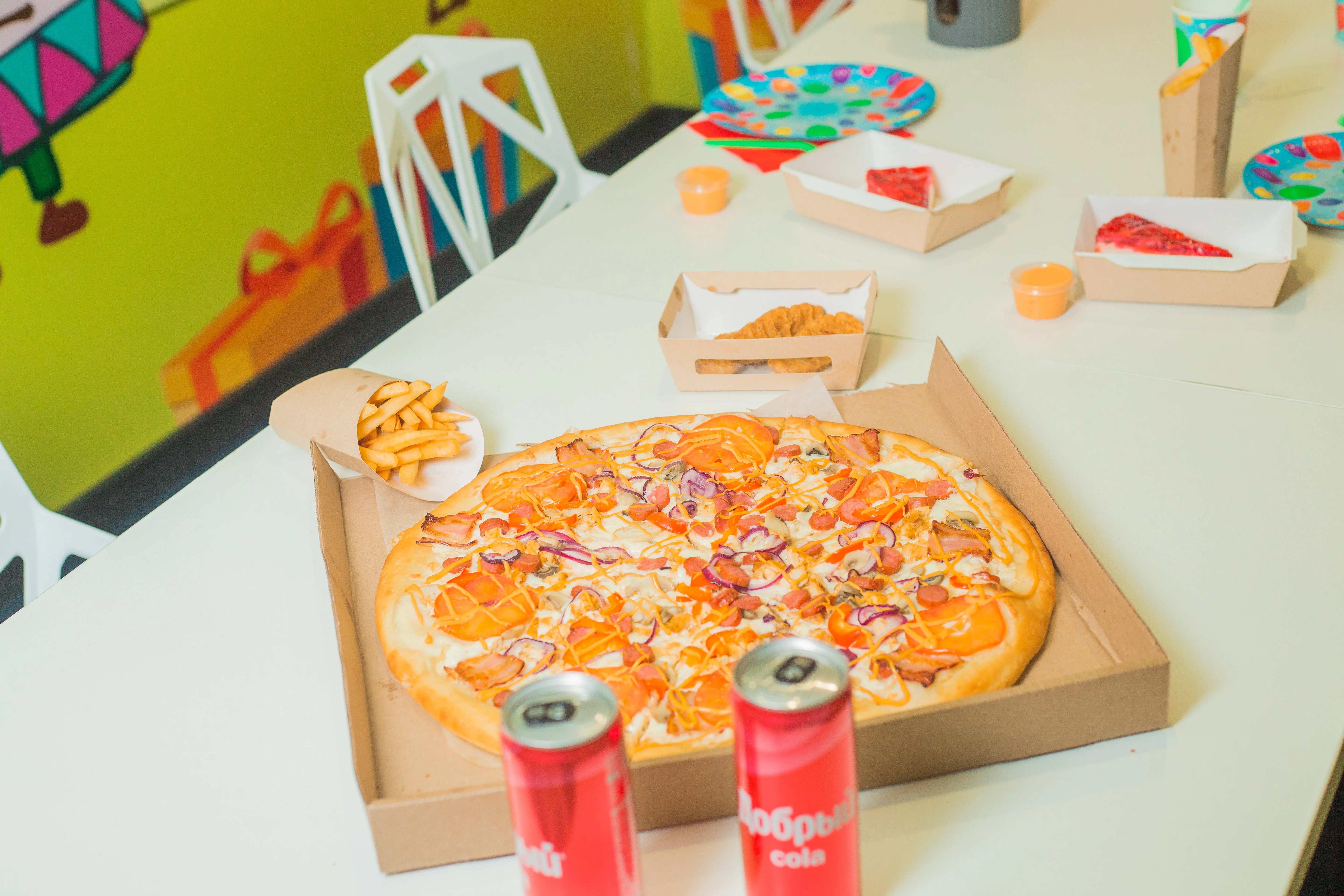 Праздничный стол с пиццей, напитками и украшениями в Крутокафе