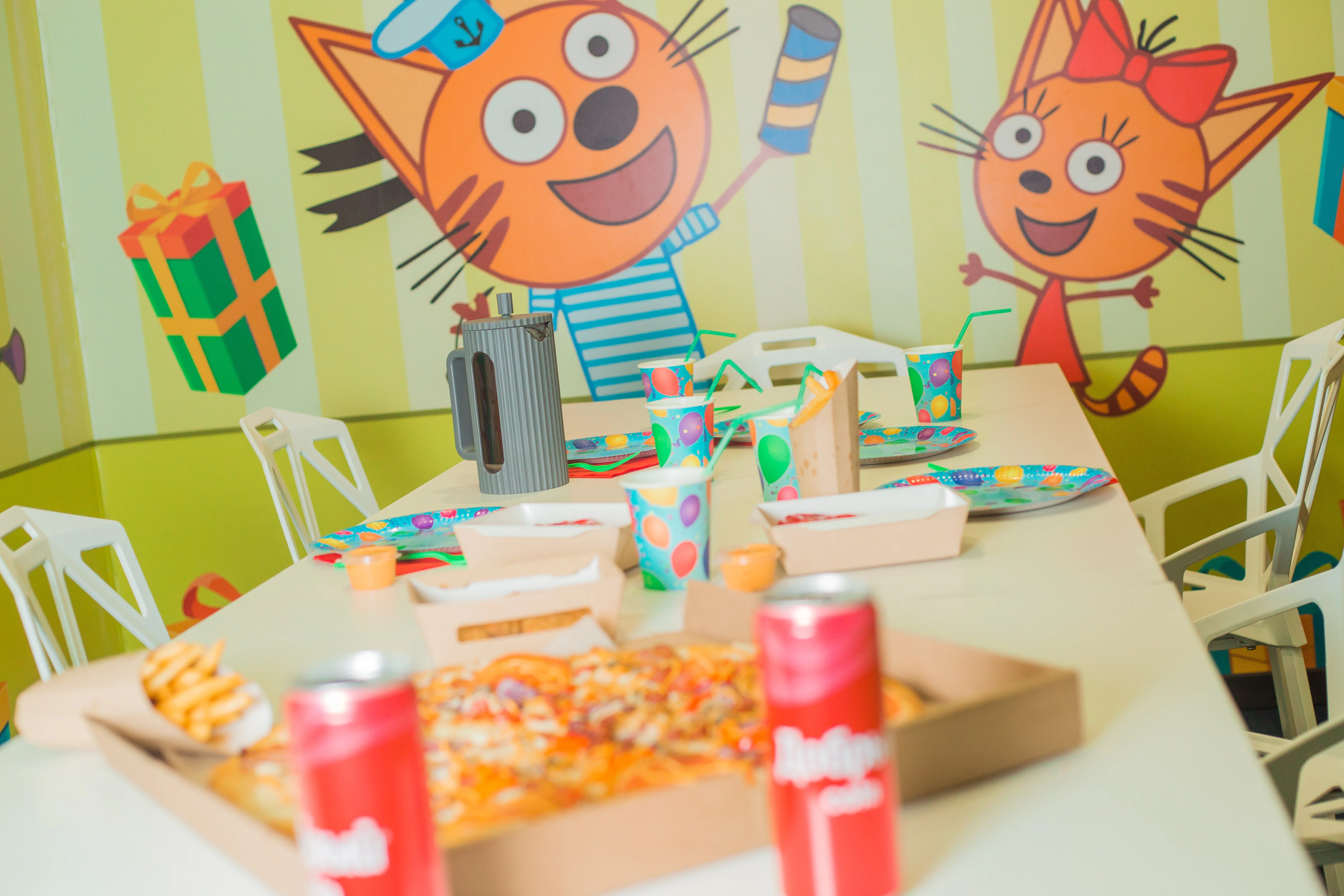 Детский праздник с едой и напитками в украшенном зале кафе